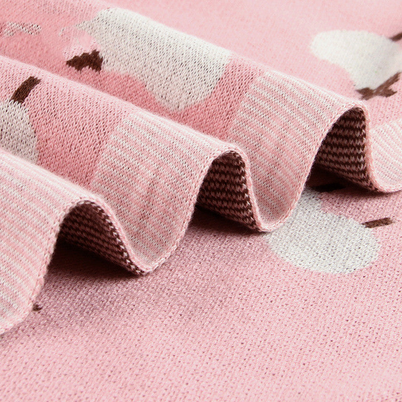 Soft pink knitted baby blanket featuring white sheep pattern, cozy and breathable for infants