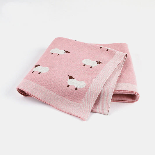 Soft pink knitted baby blanket featuring white sheep pattern, cozy and breathable for infants
